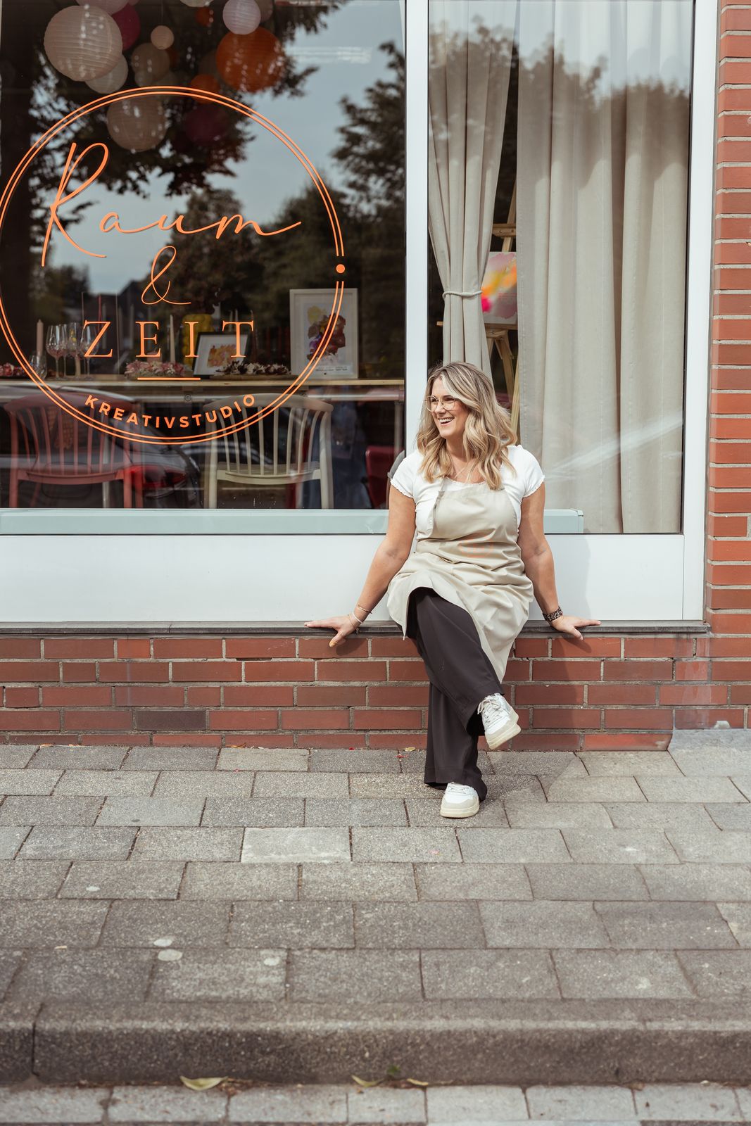 Ina Scholl vor dem Schaufenster von Kreativstudio Raum & Zeit